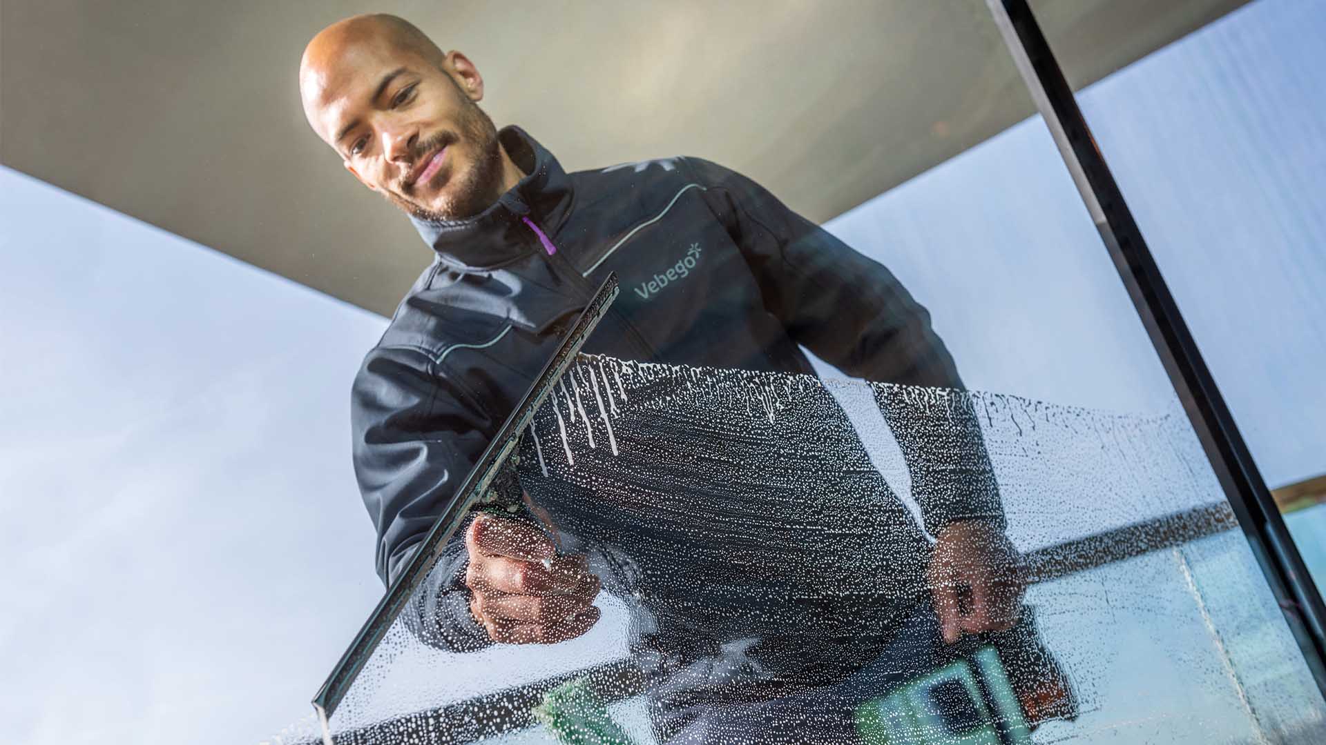 Reinigungskraft reinigt Glasfläche